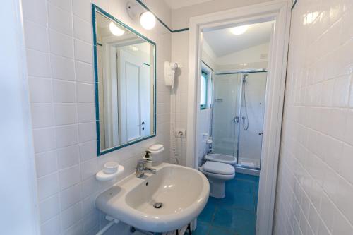 a bathroom with a sink and a toilet and a mirror at Villa Tre Mari in Villasimius