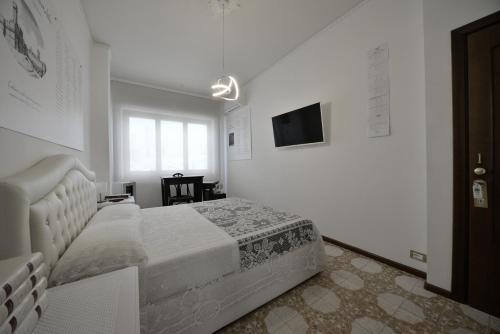 a white bedroom with a bed and a television at WAST-HOST by MICHELANGELO in Vasto
