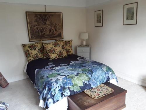 a bedroom with a bed with a blue comforter at Halcyon Days in Kenwyn