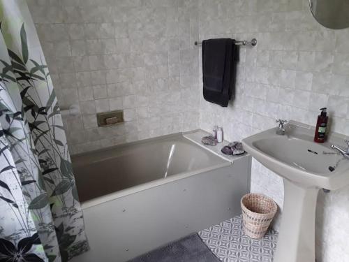 a bathroom with a white tub and a sink at Halcyon Days in Kenwyn