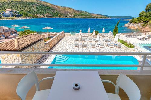 a balcony with a table and a view of the ocean at Serenity House Kassiopi in Kassiopi