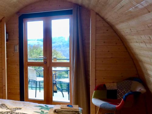 une chambre avec une grande fenêtre dans une chambre avec un lit dans l'établissement Les Trois Collines, à Saint-Cybranet