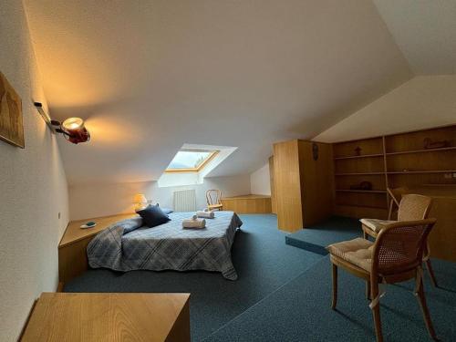 a attic room with a bed and a chair at Lake Como Serenity Suite in Lierna