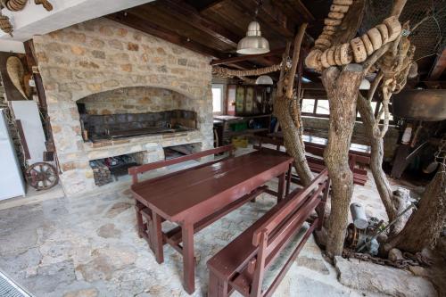 Zimmer mit einem Holztisch und einem Steinkamin. in der Unterkunft Villa Goga in Martinšćica
