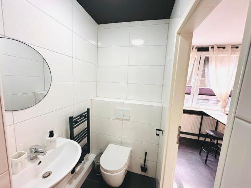 a white bathroom with a toilet and a sink at Keli Apartments Zentrum Oldenburg in Oldenburg