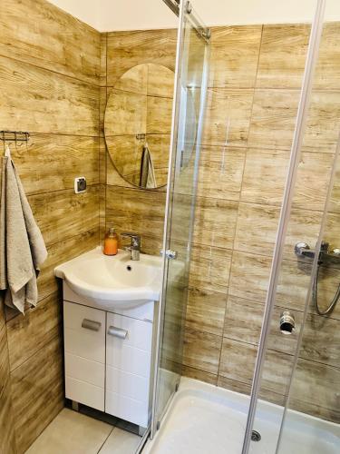a bathroom with a sink and a shower at Apartamenty w Sercu Miasta in Puck