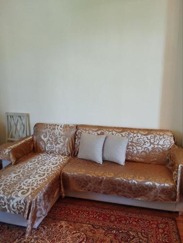 a brown leather couch with two pillows on it at Barateli in Kʼutʼaisi