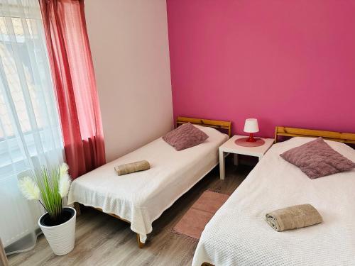 una camera con due letti e una parete rosa di Apartamenty w Sercu Miasta a Puck