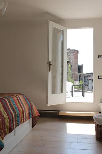 a bedroom with a bed and a sliding glass door at Casa Clarita - in centro storico in Marostica