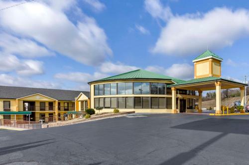 Quality Inn في هيلسفيل: مبنى كبير بسقف أخضر وموقف سيارات