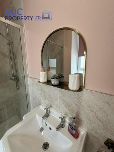 a bathroom with a sink and a mirror at Cross Wynd Apartment in Hawick