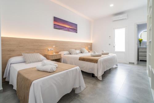 a room with three beds and a painting on the wall at Casa rural Villa Gordito in La Lantejuela