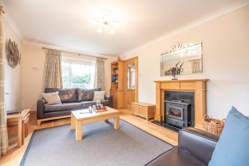 a living room with a couch and a fireplace at 5 Toller Close, Orford in Orford
