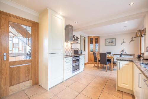 a kitchen with a table and a dining room at 5 Toller Close, Orford in Orford