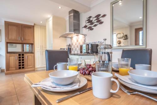 a table with cups and bowls on it in a kitchen at 5 Toller Close, Orford in Orford