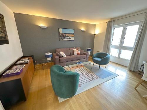 uma sala de estar com um sofá e duas cadeiras em Appartement Grand Veneur CityCosy em Paris