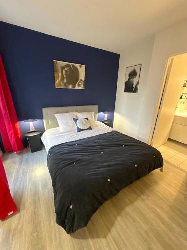 une chambre avec un grand lit avec un mur bleu dans l'établissement Appartement Grand Veneur CityCosy, à Paris