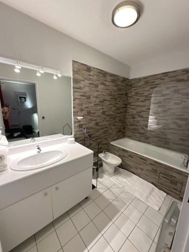 une salle de bain avec un lavabo, une baignoire et des toilettes dans l'établissement Appartement Grand Veneur CityCosy, à Paris