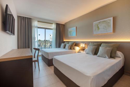 um quarto de hotel com duas camas e uma varanda em Ponient Dorada Palace by PortAventura World em Salou
