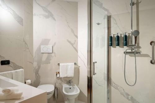 a bathroom with a shower and a toilet and a sink at Hilton Garden Inn Milan Malpensa in Somma Lombardo