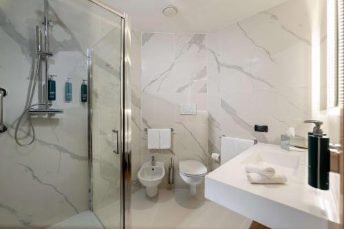 a bathroom with a shower and a toilet and a sink at Hilton Garden Inn Milan Malpensa in Somma Lombardo