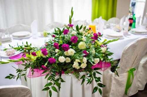 a white table with a large bouquet of flowers at Centrum Restauracyjno-Hotelowe Florres in Pawłowiczki