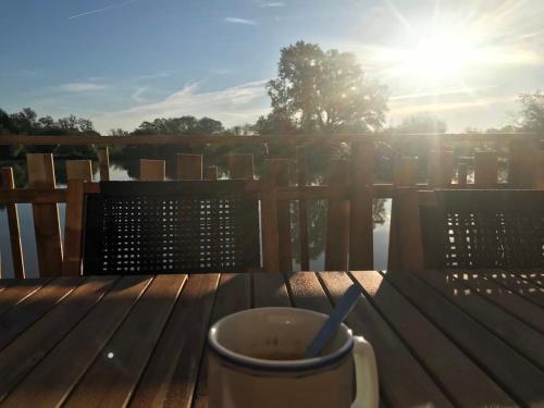 a cup of coffee sitting on a wooden table at Un étang idéal pour la famille in Moussac-sur-Vienne