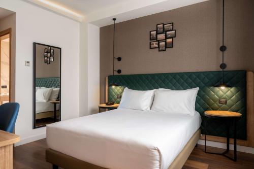 a bedroom with a large white bed and a mirror at Hilton Garden Inn Milan Malpensa in Somma Lombardo