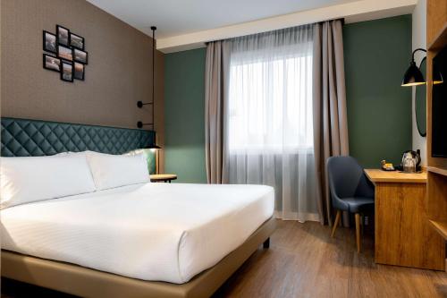 a hotel room with a bed and a desk at Hilton Garden Inn Milan Malpensa in Somma Lombardo