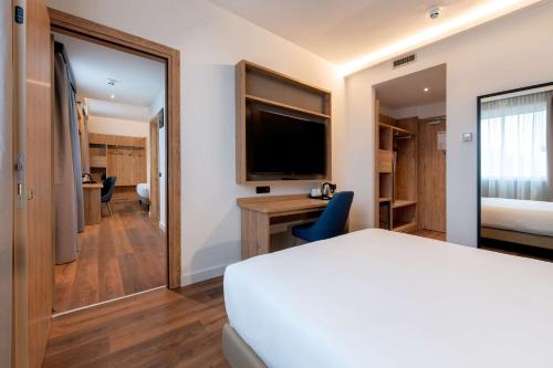 a hotel room with a bed and a television at Hilton Garden Inn Milan Malpensa in Somma Lombardo