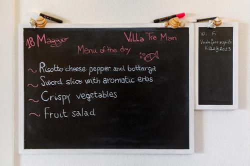 a chalkboard with a menu written on it at Villa Tre Mari in Villasimius