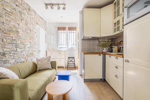 un salon avec un canapé et une cuisine dans l'établissement Appartement lumineux et cosy Gare du Nord - Opéra, à Paris
