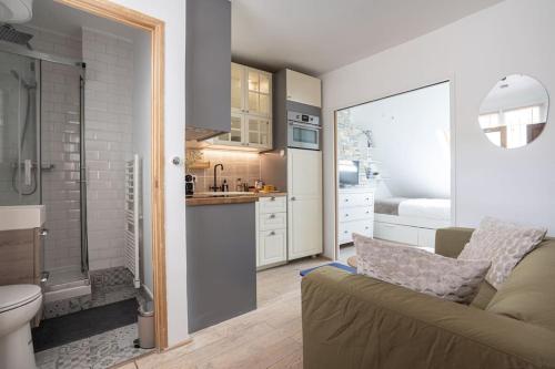 un salon avec un canapé et une salle de bains. dans l'établissement Appartement lumineux et cosy Gare du Nord - Opéra, à Paris