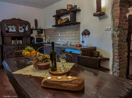 una cocina con una mesa de madera y una botella de vino en Holiday Home Gorski Lazi, en Tršće