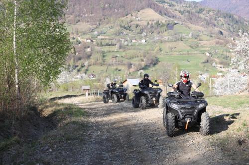 a group of people riding atvs on a dirt road at Pensiunea ACASA LA VLADUȚ in Borşa