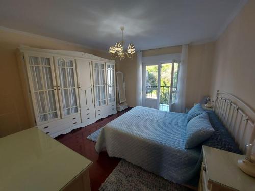 a bedroom with a bed and a chandelier at INcostadamorte Vivienda Martinez in Cee
