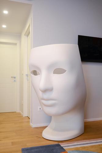 a white sculpture of a face in a room at Attico Centro con terrazza e jacuzzi e parcheggio privati in Genova