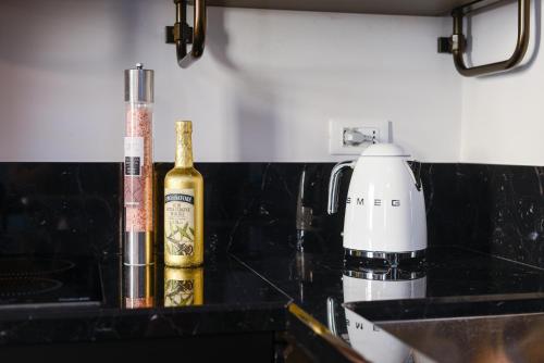 a bottle of champagne on a counter next to a blender at Attico Centro con terrazza e jacuzzi e parcheggio privati in Genova