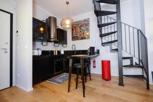 a kitchen with a black counter and a staircase at Attico Centro con terrazza e jacuzzi e parcheggio privati in Genova