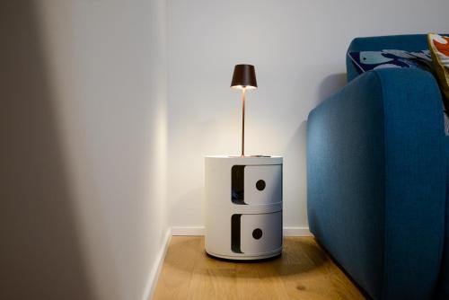 a lamp sitting on the floor next to a bed at Attico Centro con terrazza e jacuzzi e parcheggio privati in Genova