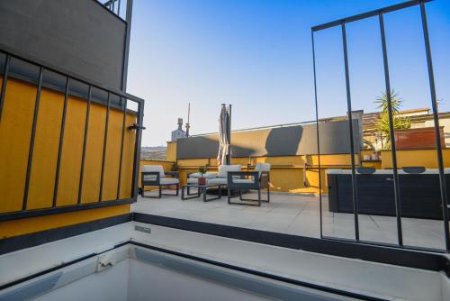 a balcony with tables and chairs on a building at Attico Centro con terrazza e jacuzzi e parcheggio privati in Genova