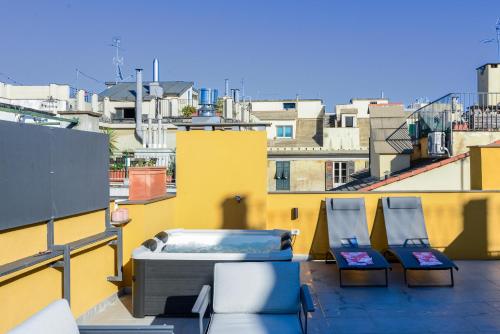 two chairs and a hot tub on a balcony at Attico Centro con terrazza e jacuzzi e parcheggio privati in Genova