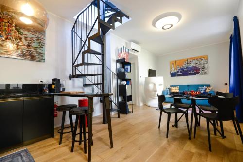 a living room with a staircase and a table and chairs at Attico Centro con terrazza e jacuzzi e parcheggio privati in Genova