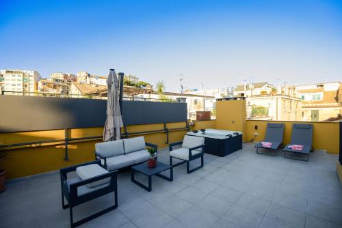 a balcony with chairs and an umbrella on a building at Attico Centro con terrazza e jacuzzi e parcheggio privati in Genova