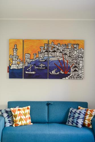 a blue couch in a room with a painting on the wall at Attico Centro con terrazza e jacuzzi e parcheggio privati in Genova