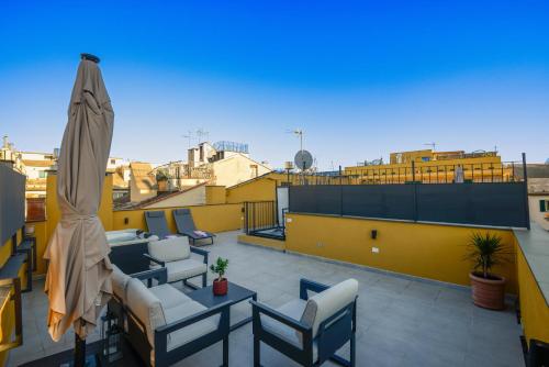 a patio with a table and chairs and an umbrella at Attico Centro con terrazza e jacuzzi e parcheggio privati in Genova