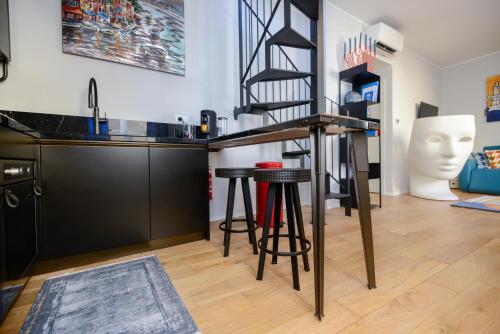 a kitchen with a bar and stools in a room at Attico Centro con terrazza e jacuzzi e parcheggio privati in Genova