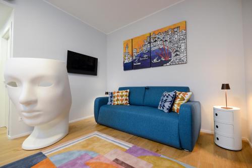 a living room with a blue couch and a statue at Attico Centro con terrazza e jacuzzi e parcheggio privati in Genova