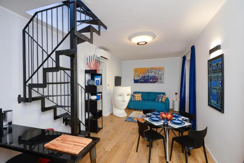 a living room with a spiral staircase and a table at Attico Centro con terrazza e jacuzzi e parcheggio privati in Genova