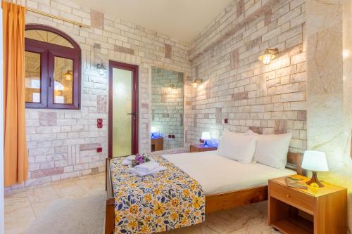 a bedroom with a bed and a brick wall at Paco's Superior Double Villa 15 in Oziás